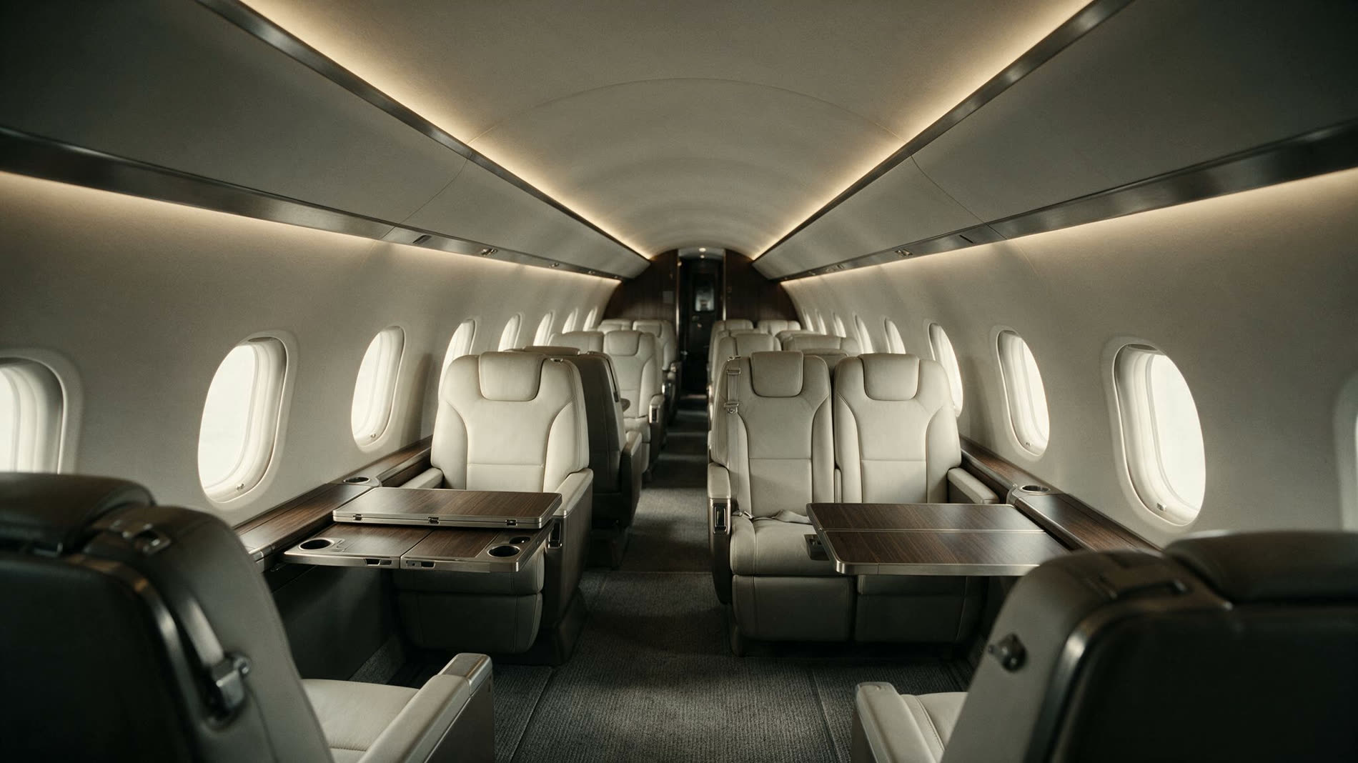 Cabina de aeronave privada vista desde el pasillo, con asientos claros y mesas de madera