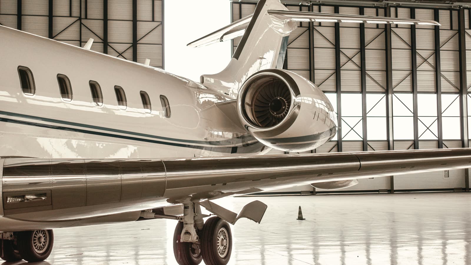 Jet ejecutivo estacionado en el interior de un hangar, a contraluz
