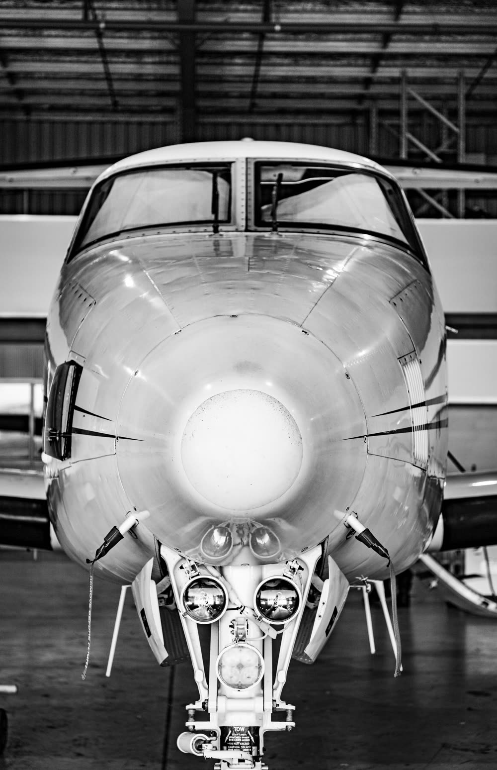 Morro de un jet ejecutivo en blanco y negro dentro de un hangar